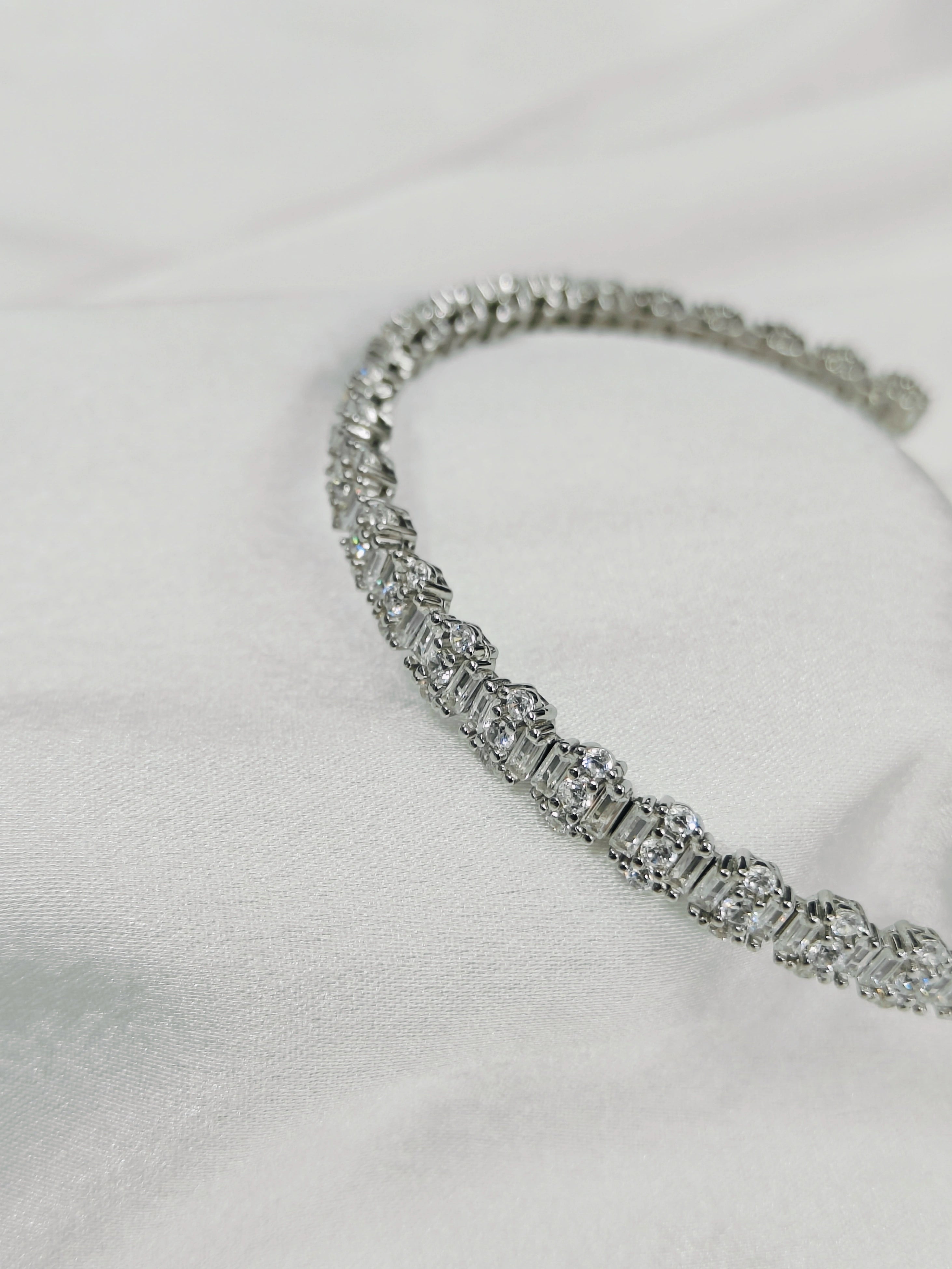 Silver bracelet with clear stones on a light gray background